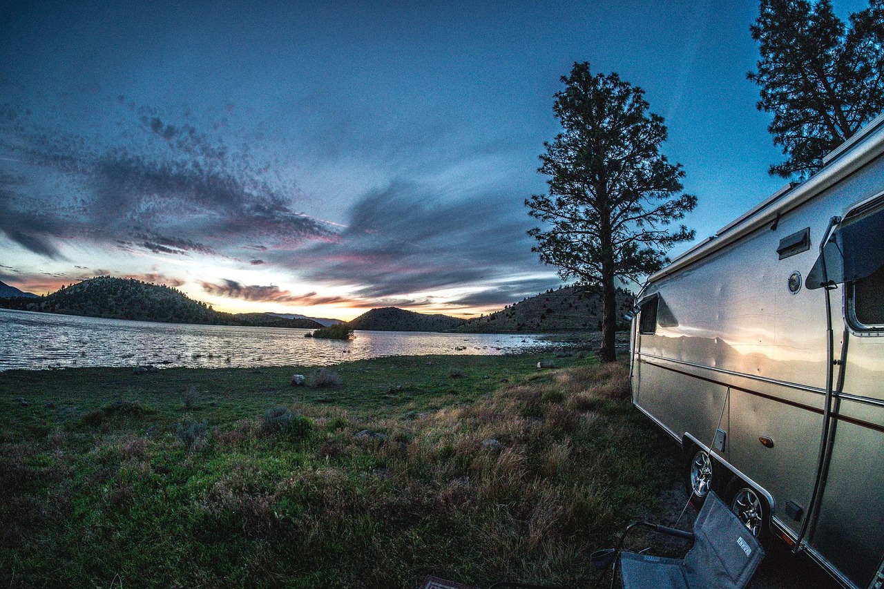 Airstream camper parked lakeside at dusk
