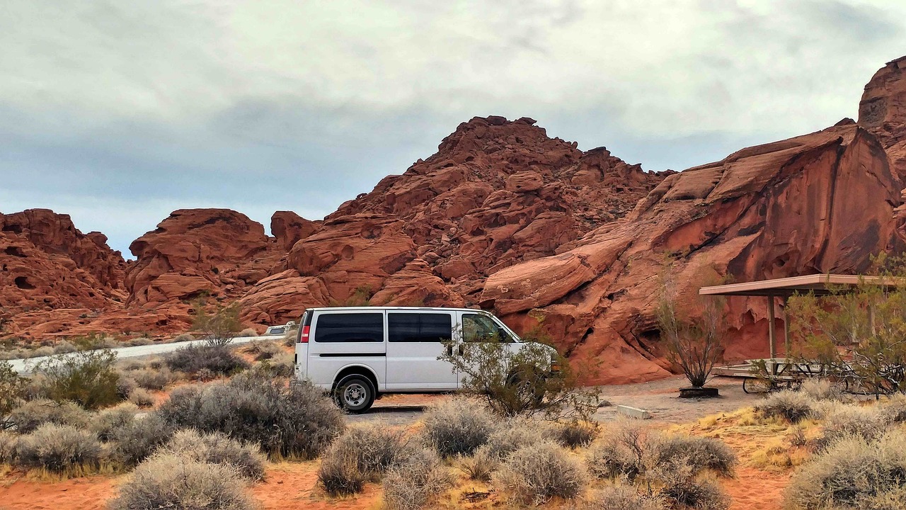 Camper van on a desert campground site with picnic shelter